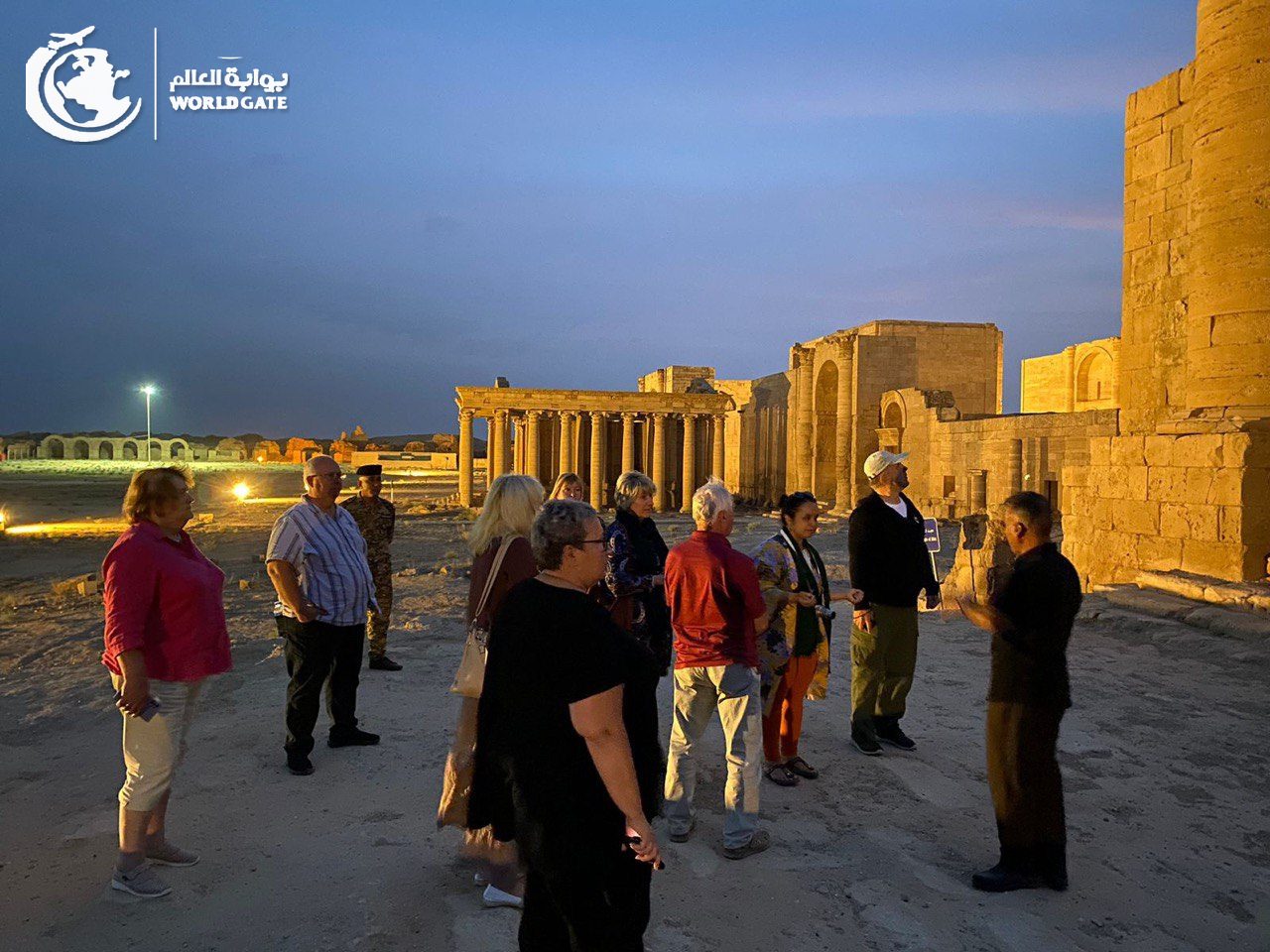 Tour group with a guide at Hatra at dusk