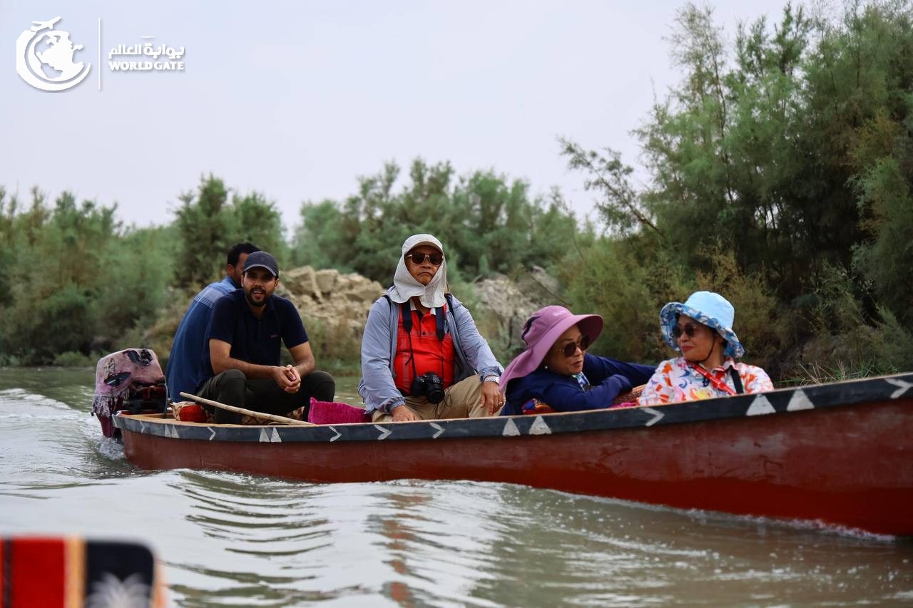 Travellers on a wooden boat along a river in southern Iraq